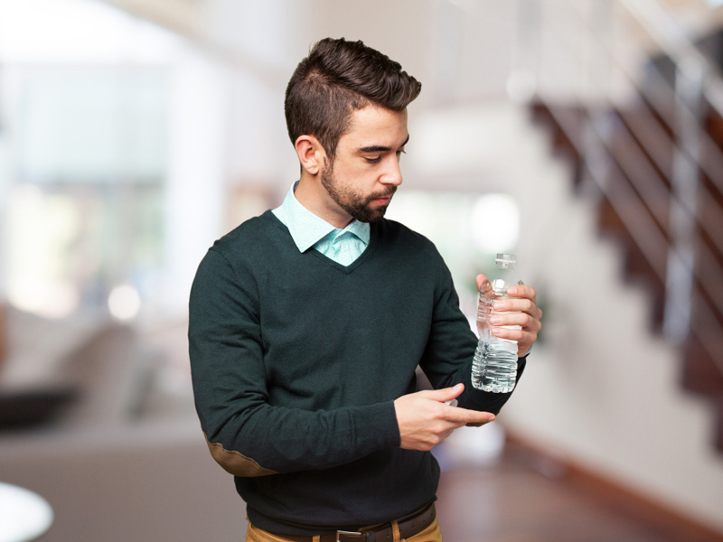 man holding water bottle and thinking